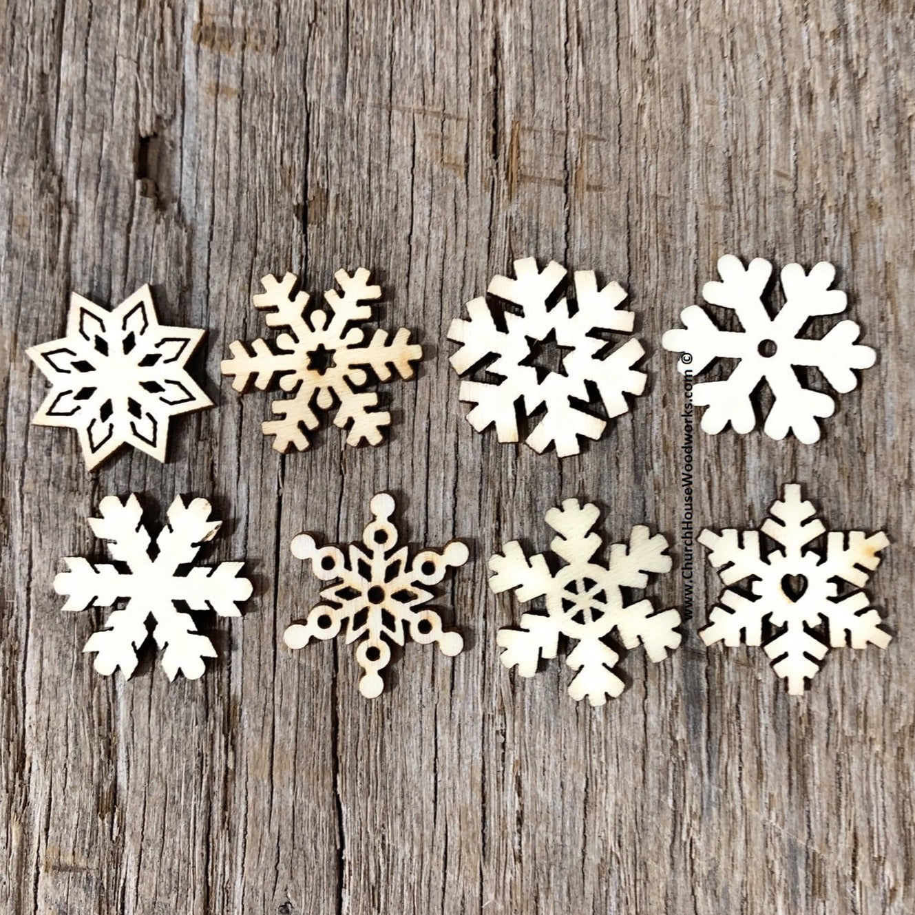 Close-up of intricately designed laser-cut wooden snowflakes, perfect for Christmas crafts, ornaments, and holiday decorations